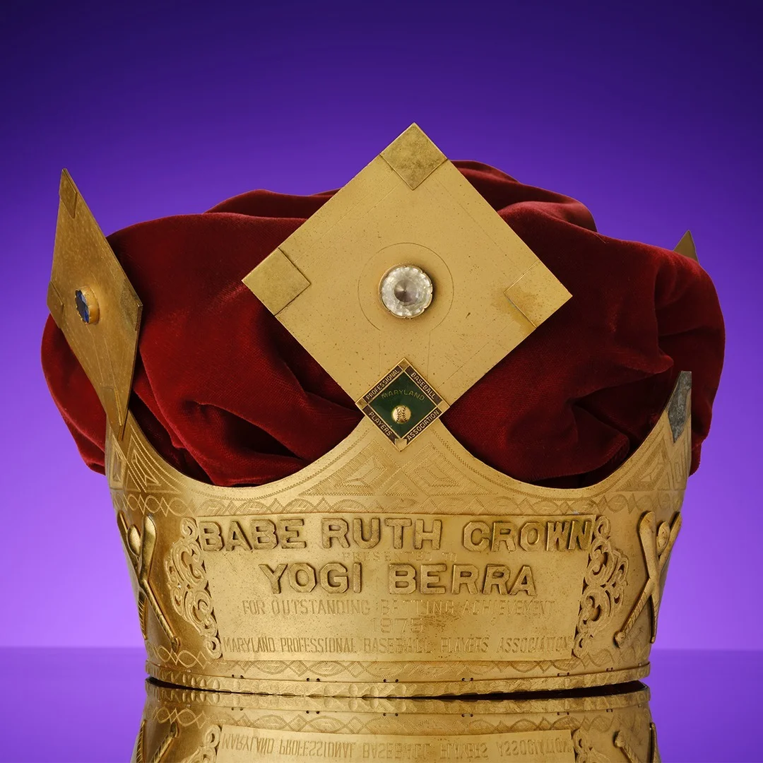 Yogi Berra’s gold Babe Ruth Crown on a purple background